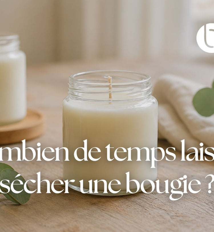 Bougie maison en cire dans un pot en verre, posée sur une table en bois pendant son temps de repos avant utilisation.