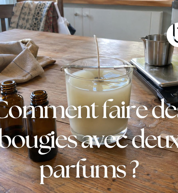 Fabrication artisanale d’une bougie parfumée avec deux flacons de parfum sur une table en bois.